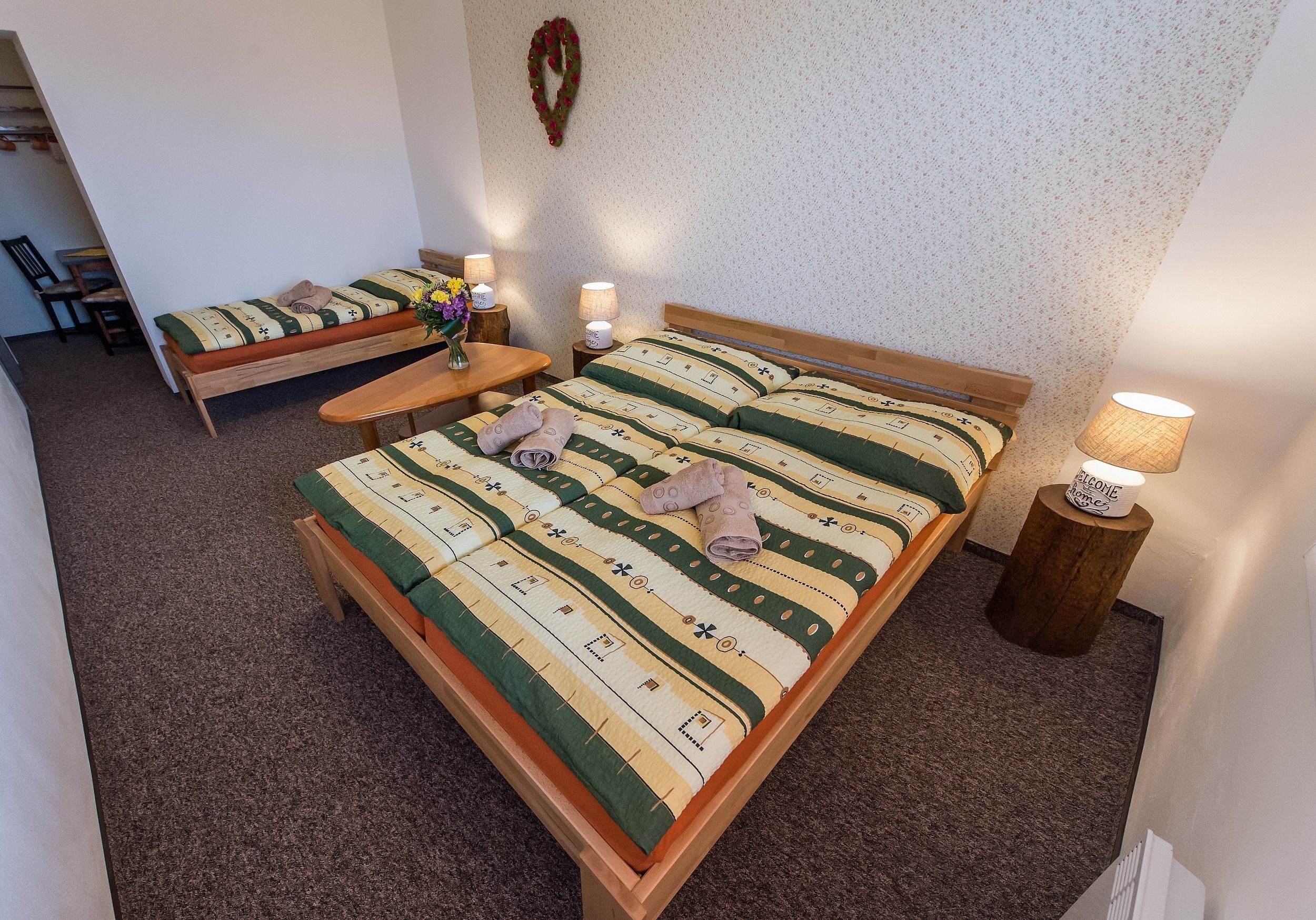 Ein Schlafzimmer mit einem Bett, einer Bank, einem Tisch und zwei Lampen.