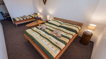 Ein Schlafzimmer mit einem Bett, einer Bank, einem Tisch und zwei Lampen.