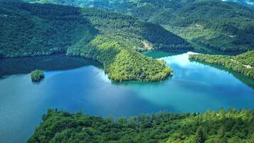 A serene lake surrounded by dense forested hills.