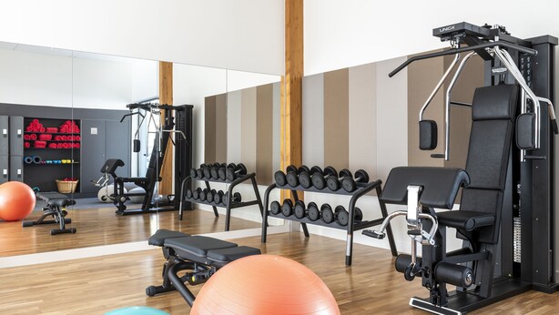 A gym with exercise equipment, dumbbells, and exercise balls. - Eau Thermale Avene L'hotel (Avene)