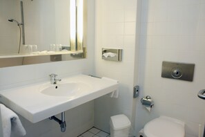 Bathroom features a sink, mirror, toilet, and shower.