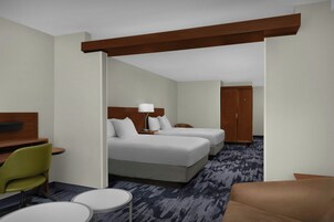 Una habitación de hotel con una cama, dos mesitas de noche, un escritorio, una silla y un armario.
