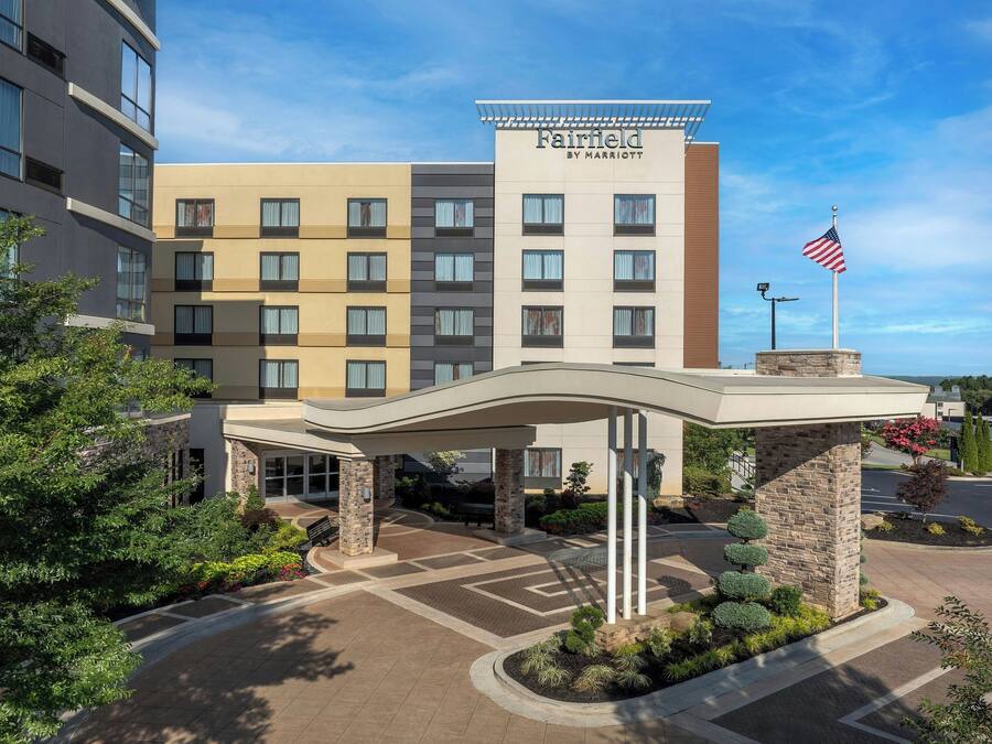 Entrada de un hotel Fairfield by Marriott con un corredor cubierto, bandera y zona ajardinada.