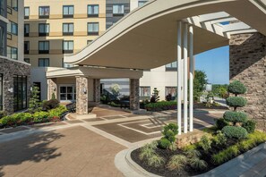 A hotel entrance with a covered walkway, stone pillars, and a landscaped garden. - Fairfield Inn & Suites Atlanta Lithia Springs (Lithia Springs)