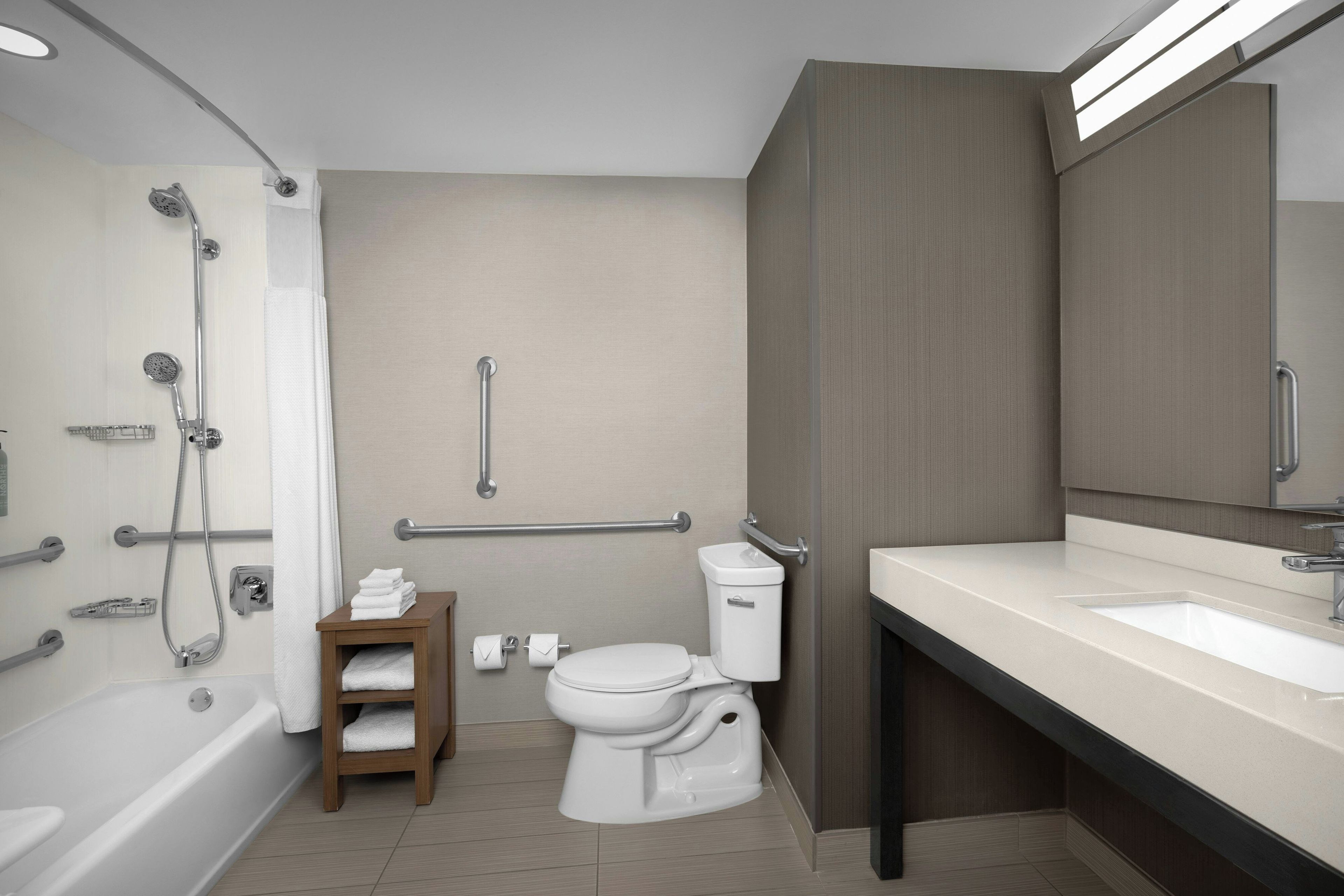A modern bathroom with a bathtub, toilet, and sink.