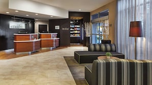 Un vestíbulo moderno con mostrador de recepción, zona de estar y bar de aperitivos.