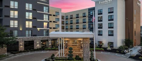 A Courtyard by Marriott hotel with a modern design, featuring a central courtyard with a fountain and surrounded by a landscaped garden.
