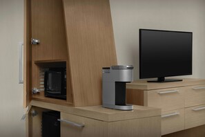 A modern kitchen with a built-in microwave, a coffee machine, and a flat-screen TV on a wooden countertop. - Courtyard by Marriott Atlanta Lithia Springs (Lithia Springs)