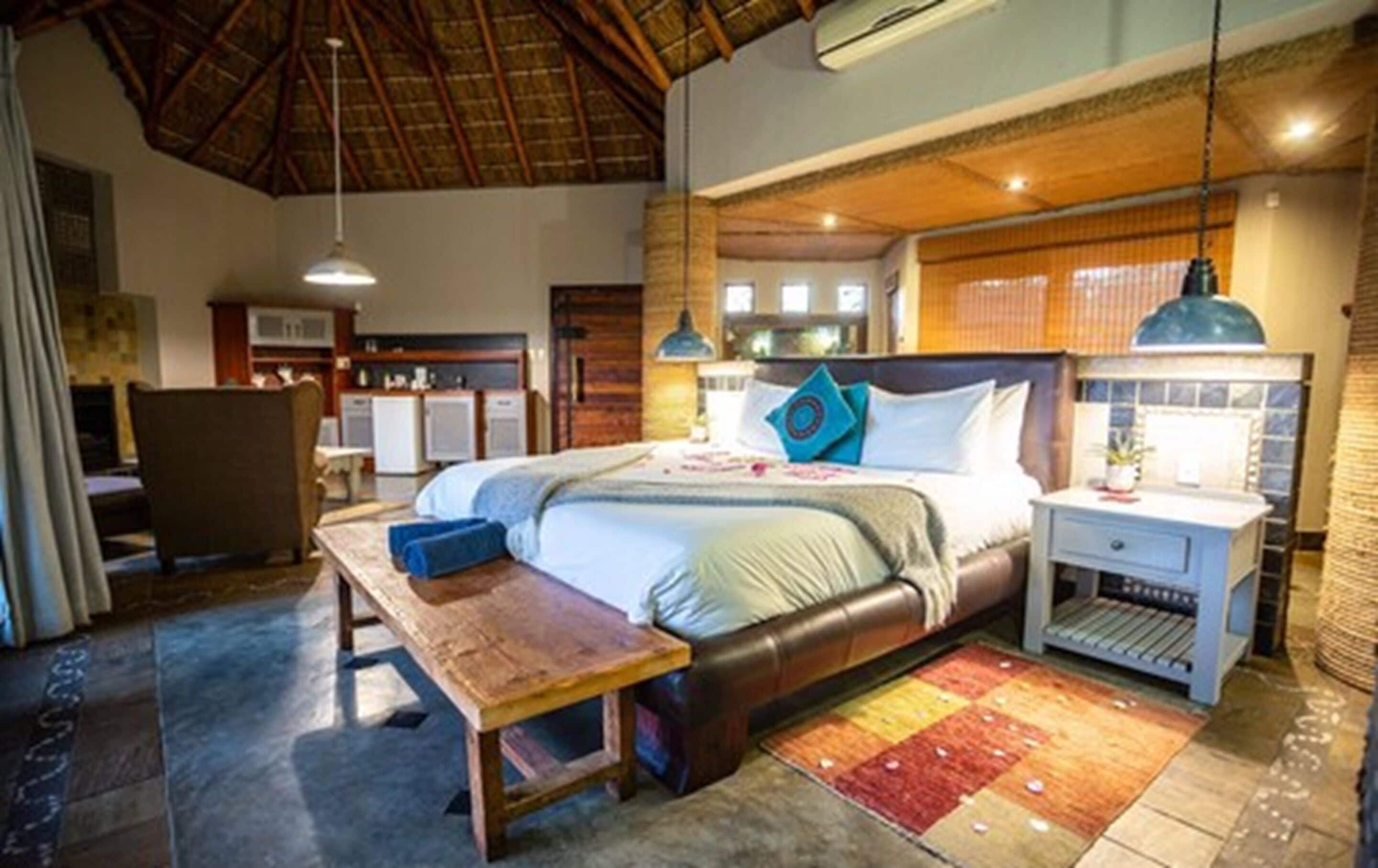 Un'ampia camera da letto con un letto grande, una panca in legno, un comodino e una scrivania.