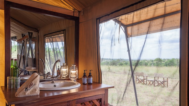 A wooden vanity with a sink, a towel, and toiletries. - Gnu Ndutu Camp (Ngorongoro)