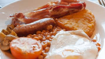 Un plato de comida para el desayuno con huevos, tocino, frijoles y tostadas.