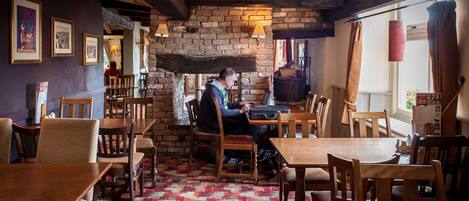 A cozy restaurant with wooden furniture and a brick wall.