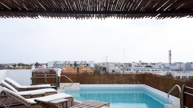 A rooftop pool with wooden loungers and a view of the cityscape. - Papaya 20 by CocoBR (Playa del Carmen)
