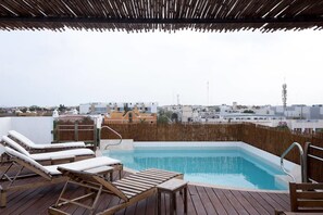 A rooftop pool with wooden loungers and a view of the cityscape. - Papaya 20 by CocoBR (Playa del Carmen)