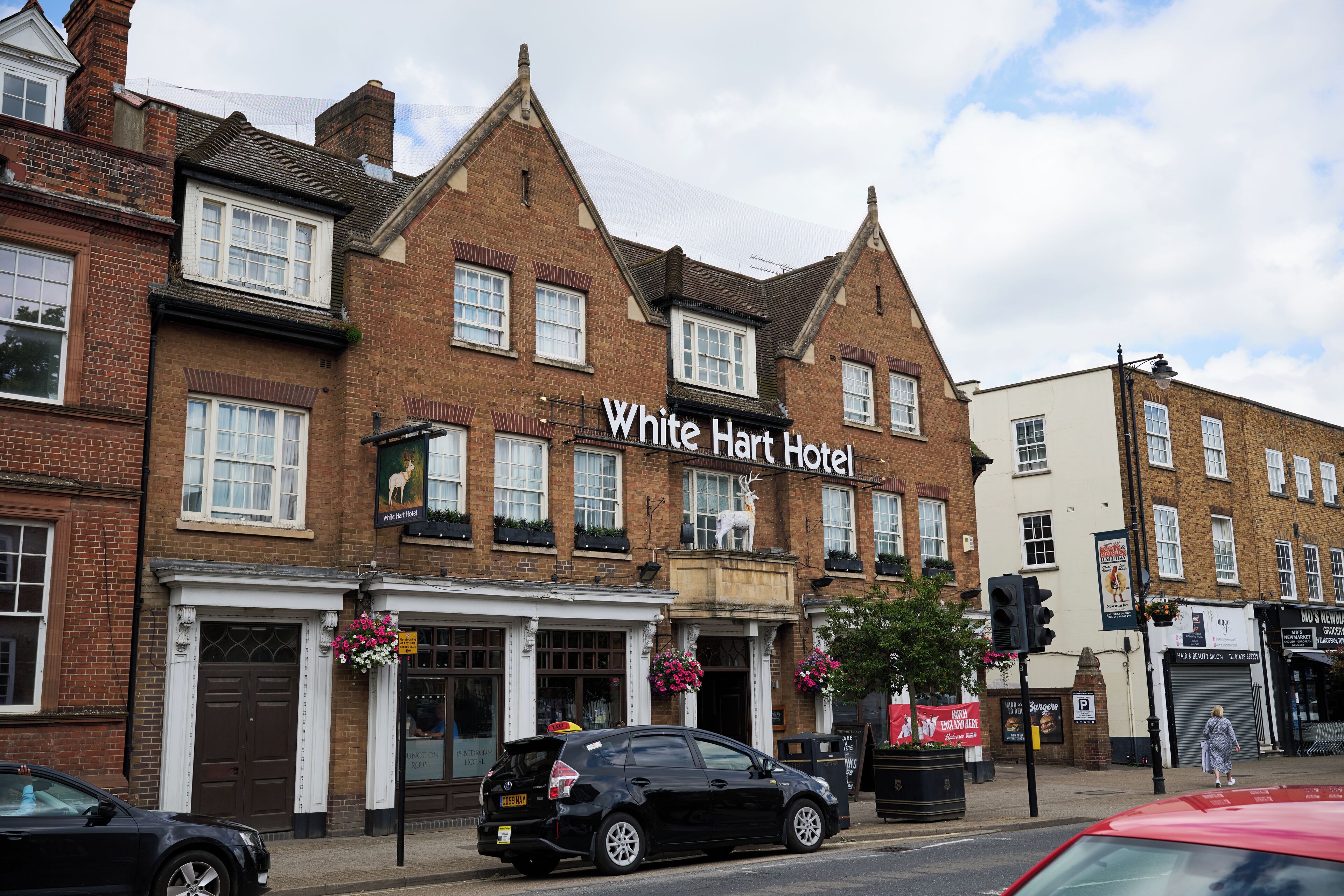 A traditional brick building with a sign reading "White Hart Hotel."