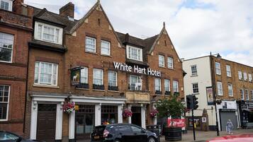 A traditional brick building with a sign reading "White Hart Hotel."