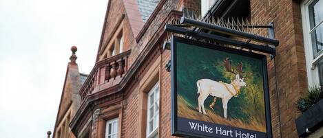 Een bord voor Hotel White Hart met een illustratie van een hert.