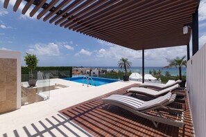 A rooftop pool area with lounge chairs and a view of the ocean. - Menesse 205 by CocoBR (Playa del Carmen)