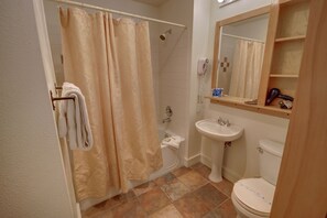 A bathroom with a shower, toilet, sink, and a mirror. - Silver Mill 8227 (Keystone)