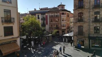 A square with buildings on all sides, outdoor seating, and a few people walking.
