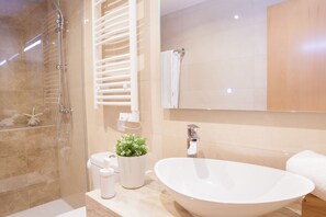 Badkamer | Een douche, een haardroger, handdoeken, zeep