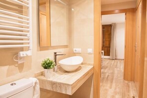 A modern bathroom with a freestanding bathtub, a towel rack, and a mirror. - Apartamentos Boutique Salamanca (Salamanca)