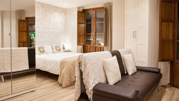 Un dormitorio moderno con una cama grande, un sofá y un armario.