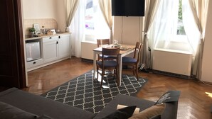 Une cuisine moderne avec un coin repas, un téléviseur à écran plat et un canapé.