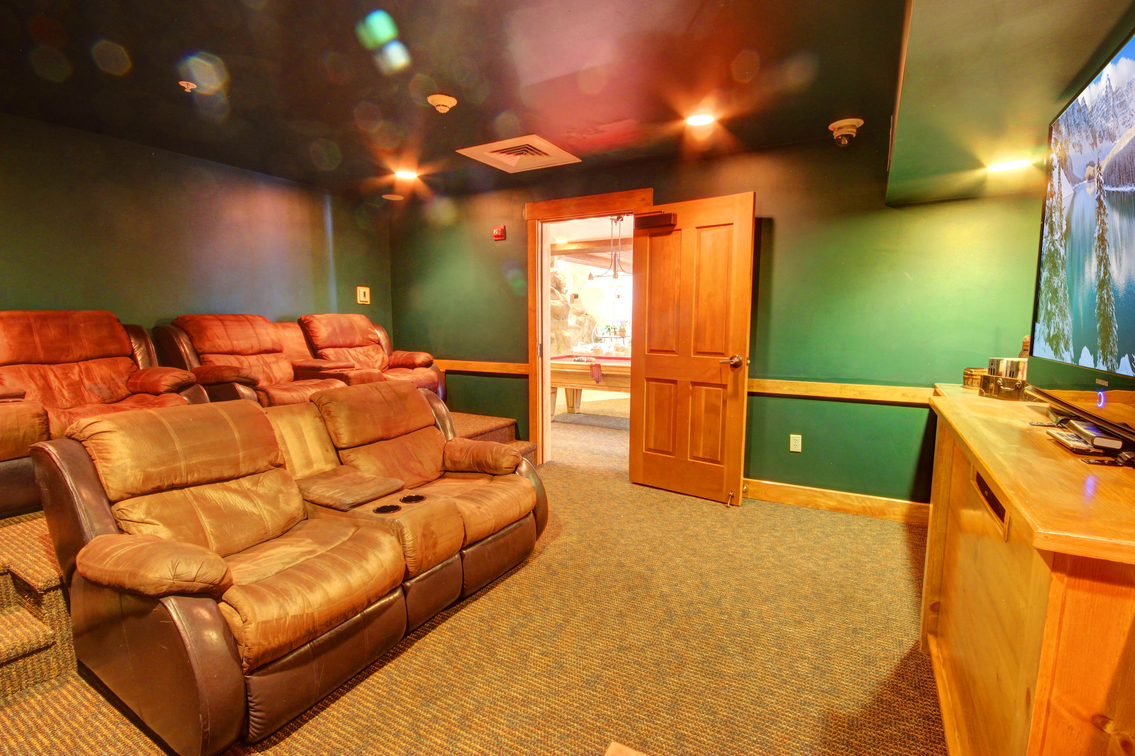 A room with a leather sofa, a wooden desk, and a green wall.