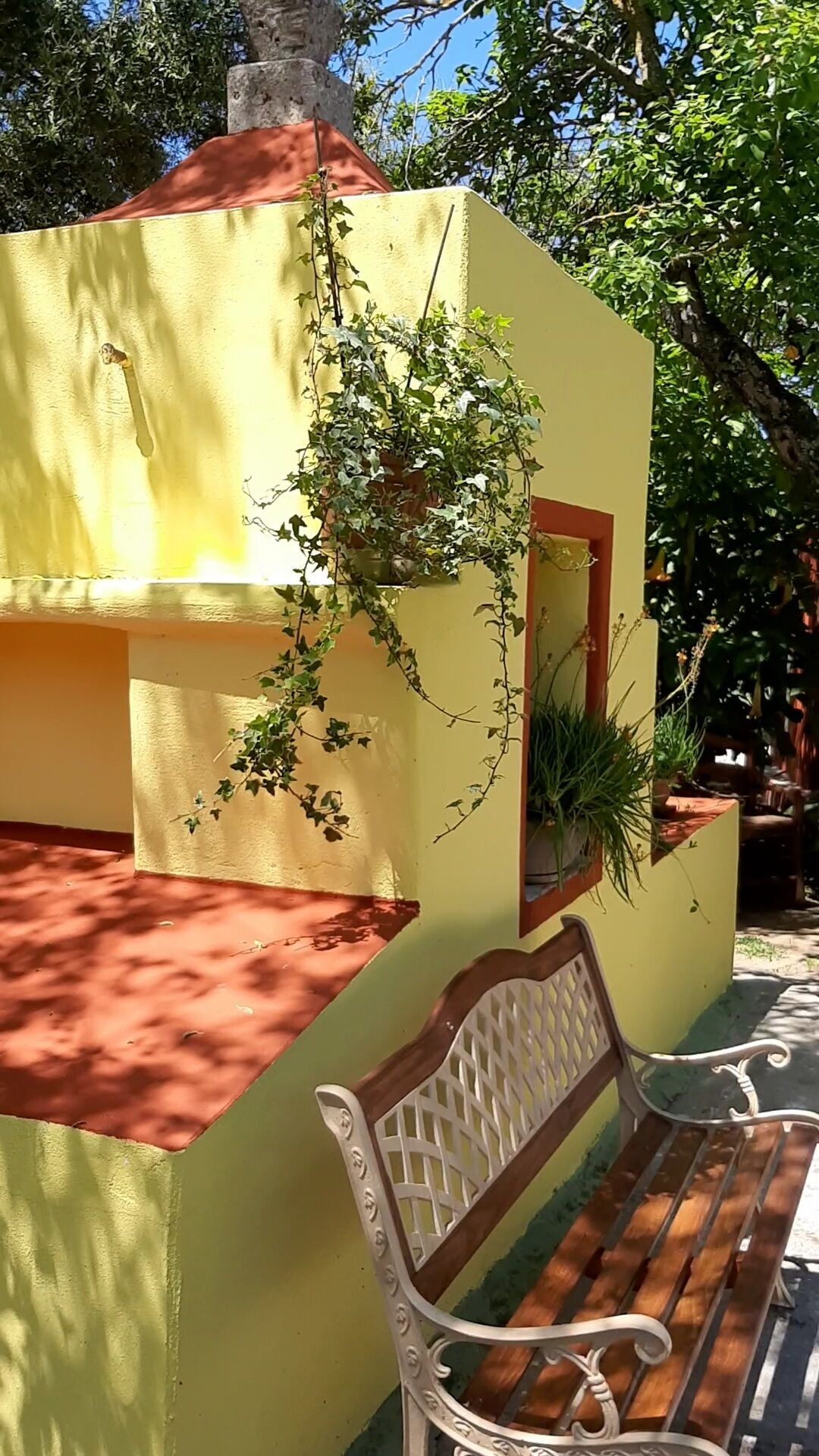A yellow building with a bench in front.