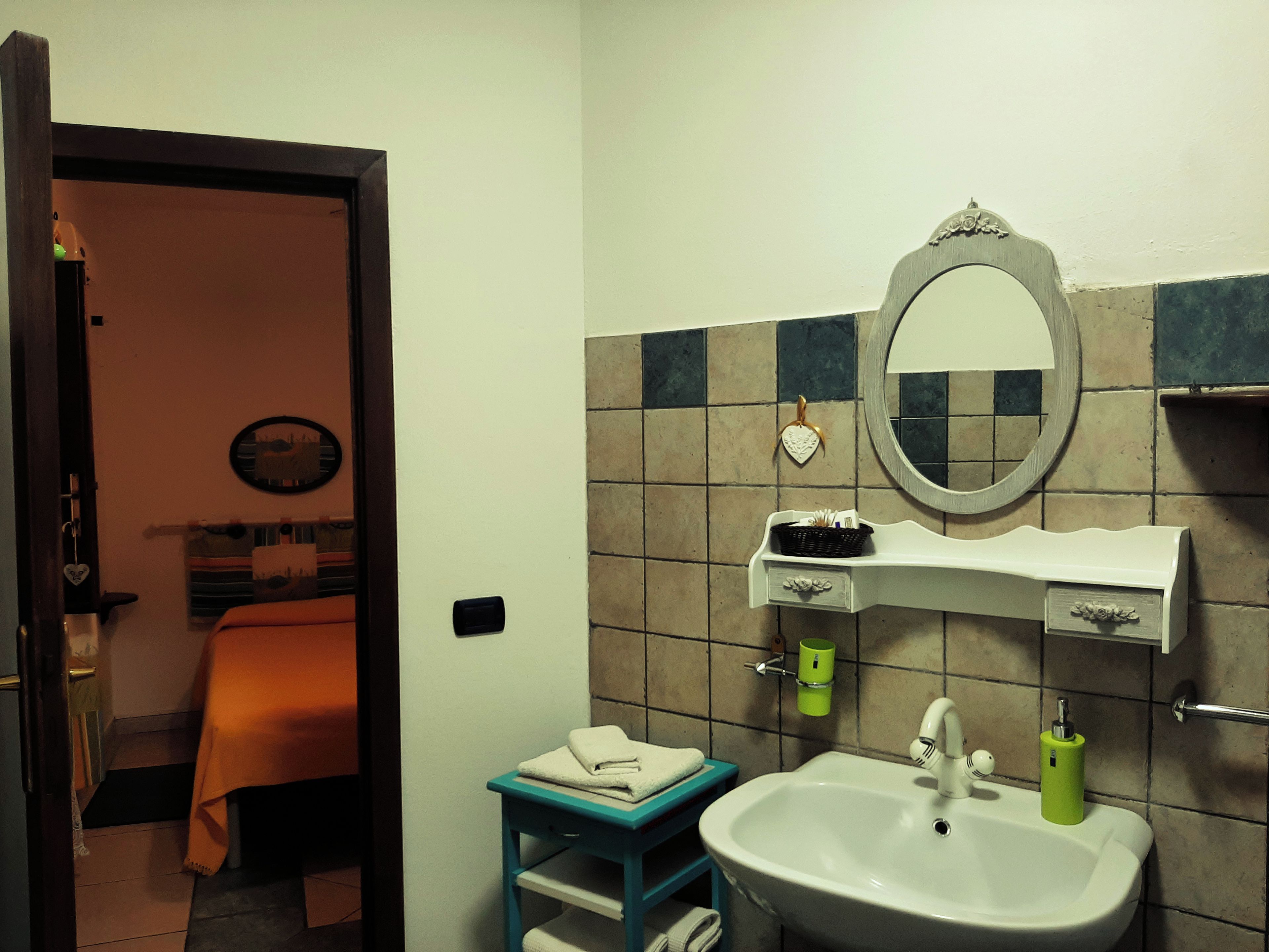 Une salle de bain avec un lavabo, un miroir et une petite table sur laquelle sont posées des serviettes.