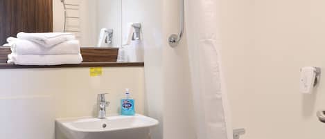 Un baño con inodoro, lavamanos, ducha y bañera.