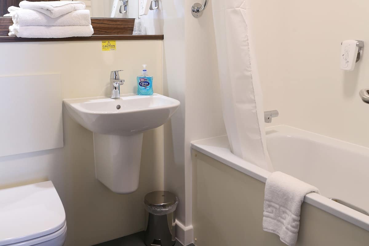 A bathroom with a toilet, sink, shower, and bathtub.