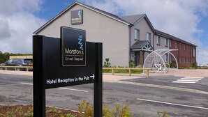 A sign for Marston's Hotel Reception in the Pub, with a building in the background. - Harbour Spring, Peterhead by Marston's Inns (Peterhead)