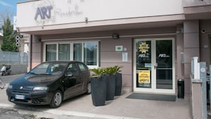 A building with a sign reading "ART Residence" and a car parked in front. - Residence Art (Rimini)