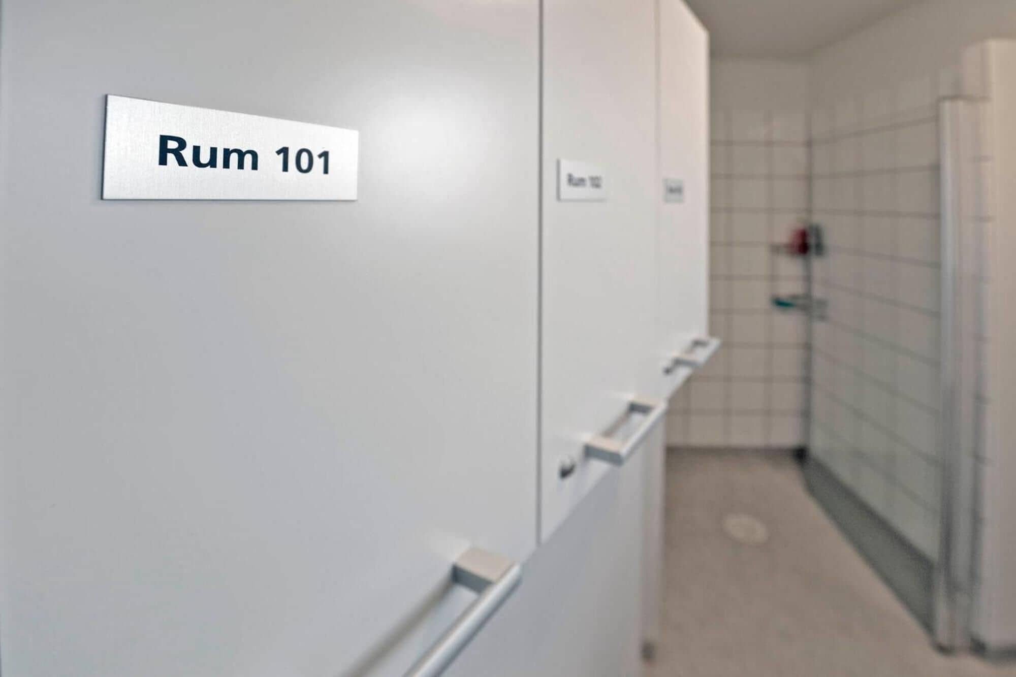 Un bagno con un cartello che indica "Rum 101" su un armadietto.