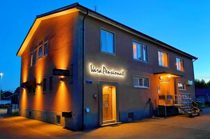 Um edifício com uma placa indicando "Vera Pensionat" e uma escadaria que leva à entrada.