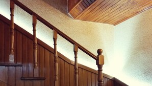 A wooden staircase with a handrail and a sloped ceiling. - Villa Vera Mini Hotel (Tbilisi)