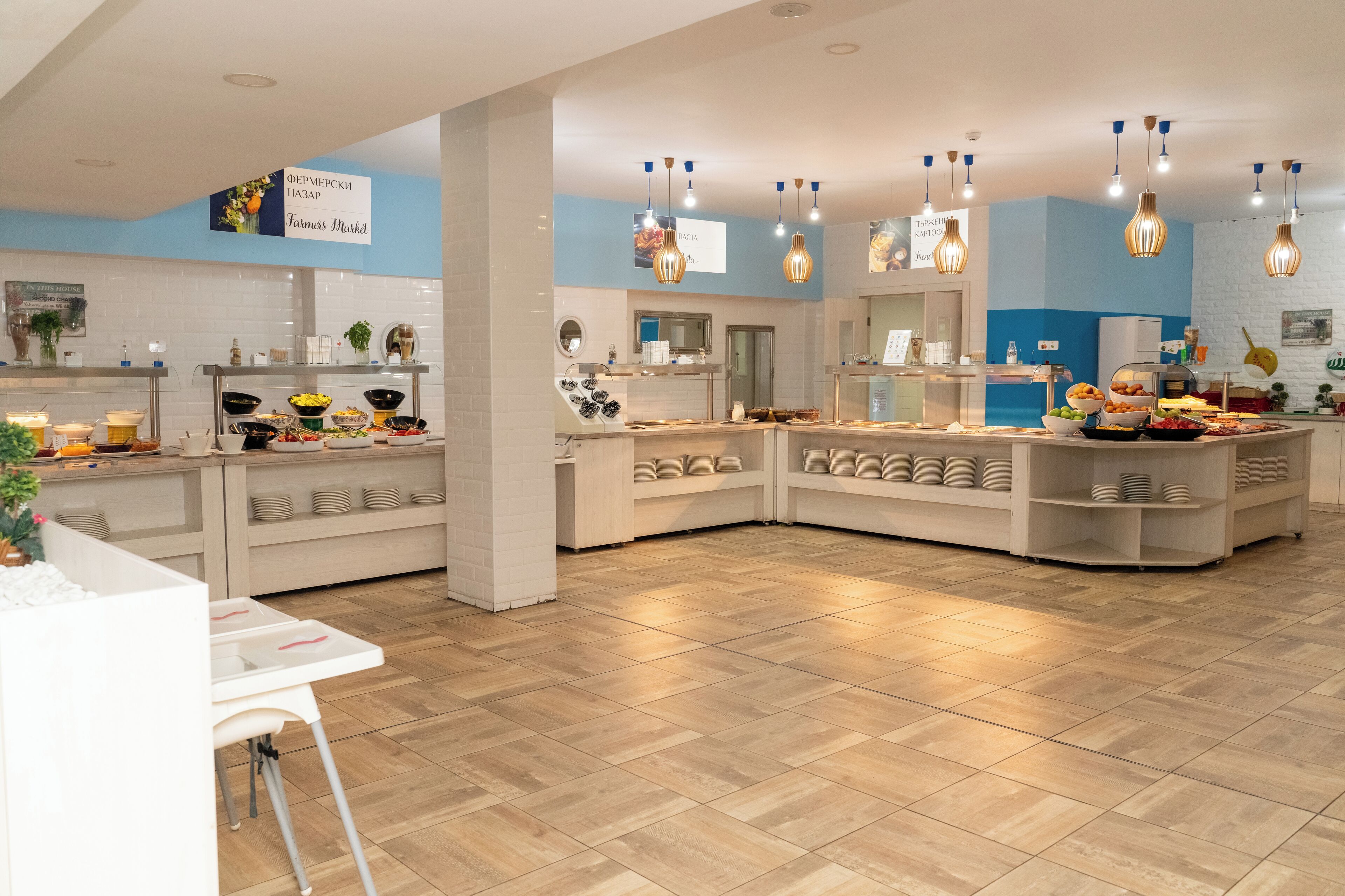 Un moderno bufé de desayuno con varias estaciones de servicio, una distribución limpia y luminarias contemporáneas.