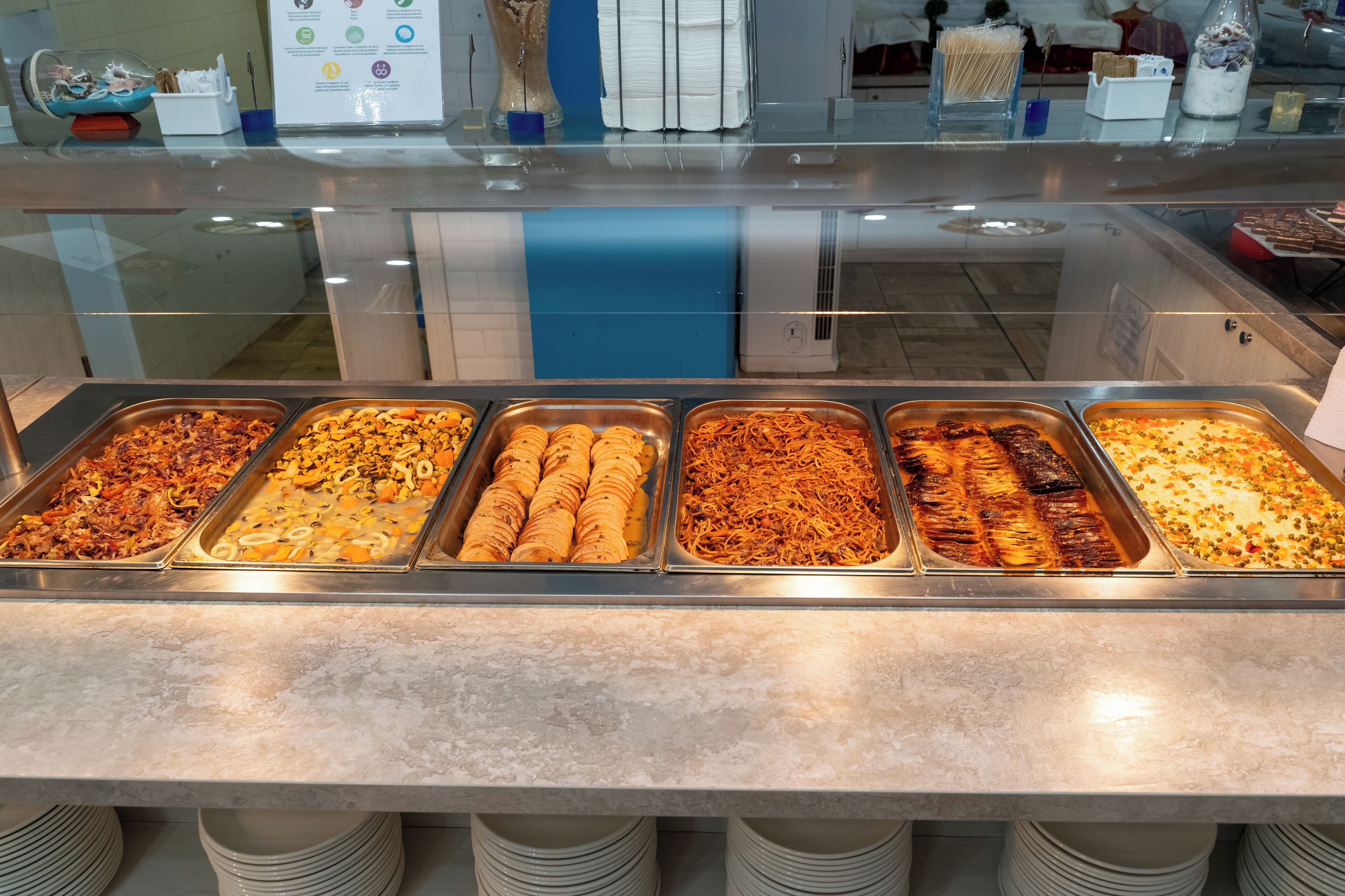 A buffet with various food items in trays.