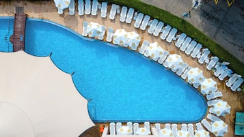 Relax by the long, curved pool surrounded by lounge chairs and umbrellas.