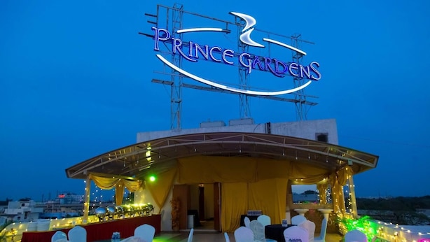 A covered outdoor area with a sign reading "Prince Gardens" and tables set up for an event. - Hotel Prince Gardens (Coimbatore)