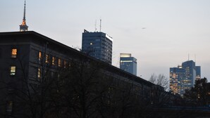A cityscape with modern and historic buildings, including a prominent clock tower. - West Apartments Mazowiecka 7 (Warsaw)
