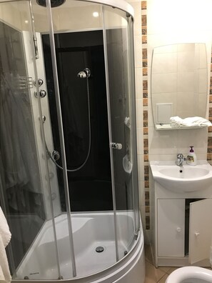 Eenvoudig appartement | Badkamer | Een douche, een haardroger, pantoffels, handdoeken