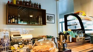 A bakery counter with a waffle display, a cash register, and shelves with various bottles.