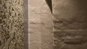 Um quarto com parede revestida em azulejos e parede com textura.