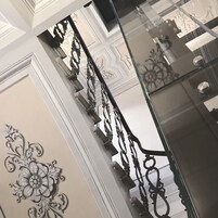 Una scala con ringhiere in metallo elaborate e pannelli decorativi.