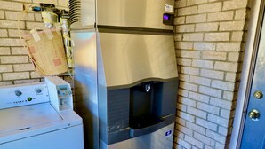 A compact laundry area with a washing machine and a water dispenser. - Regency Inn & Suites (Gladewater)