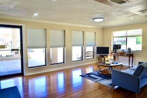 A spacious living room with a large sofa, a coffee table, and a television.
