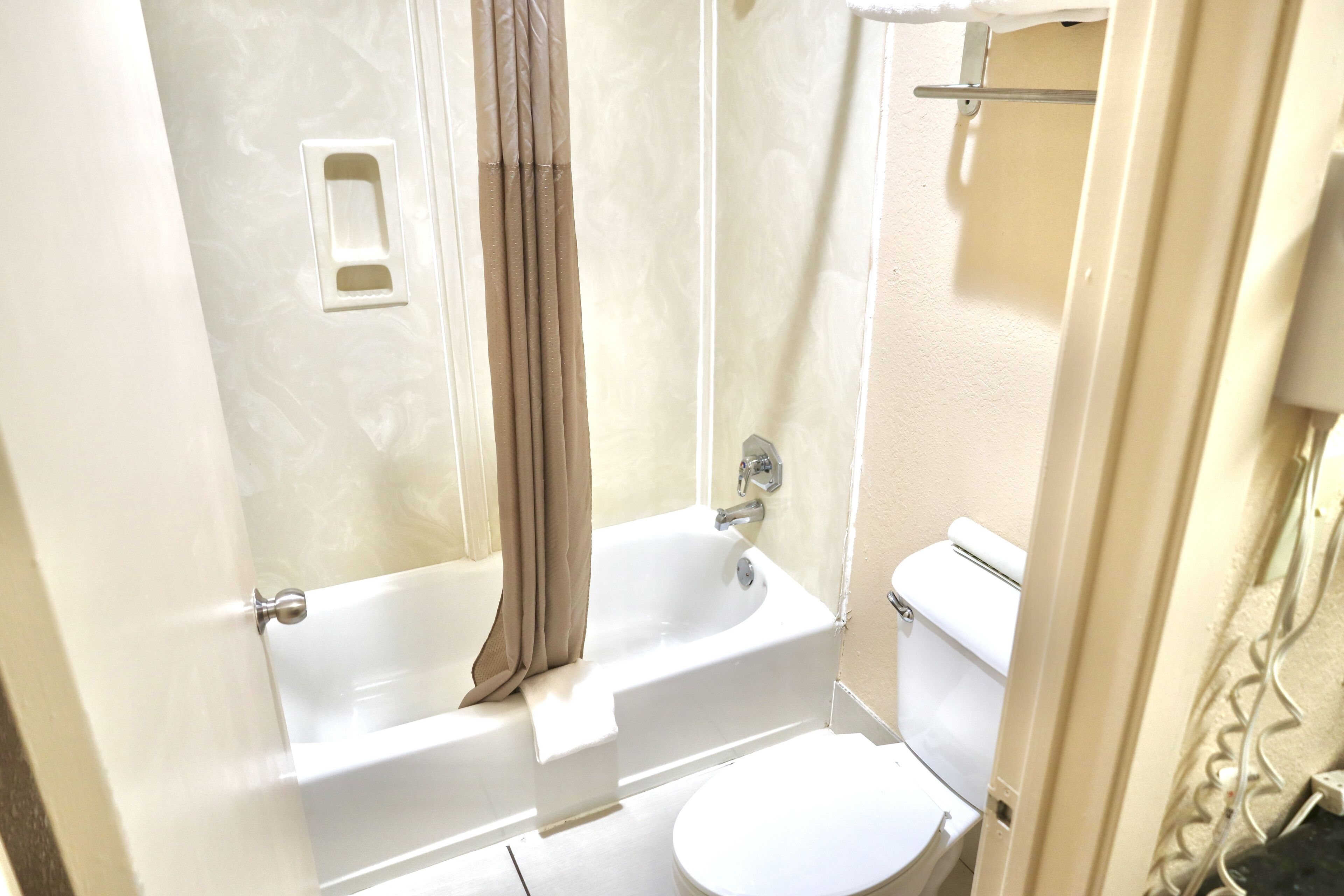 Un baño con bañera, inodoro y cortina de ducha.